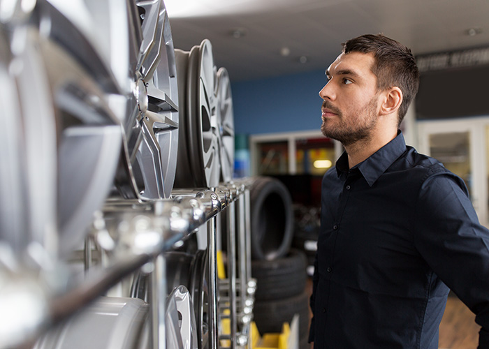 male customer choosing wheel rims at car service